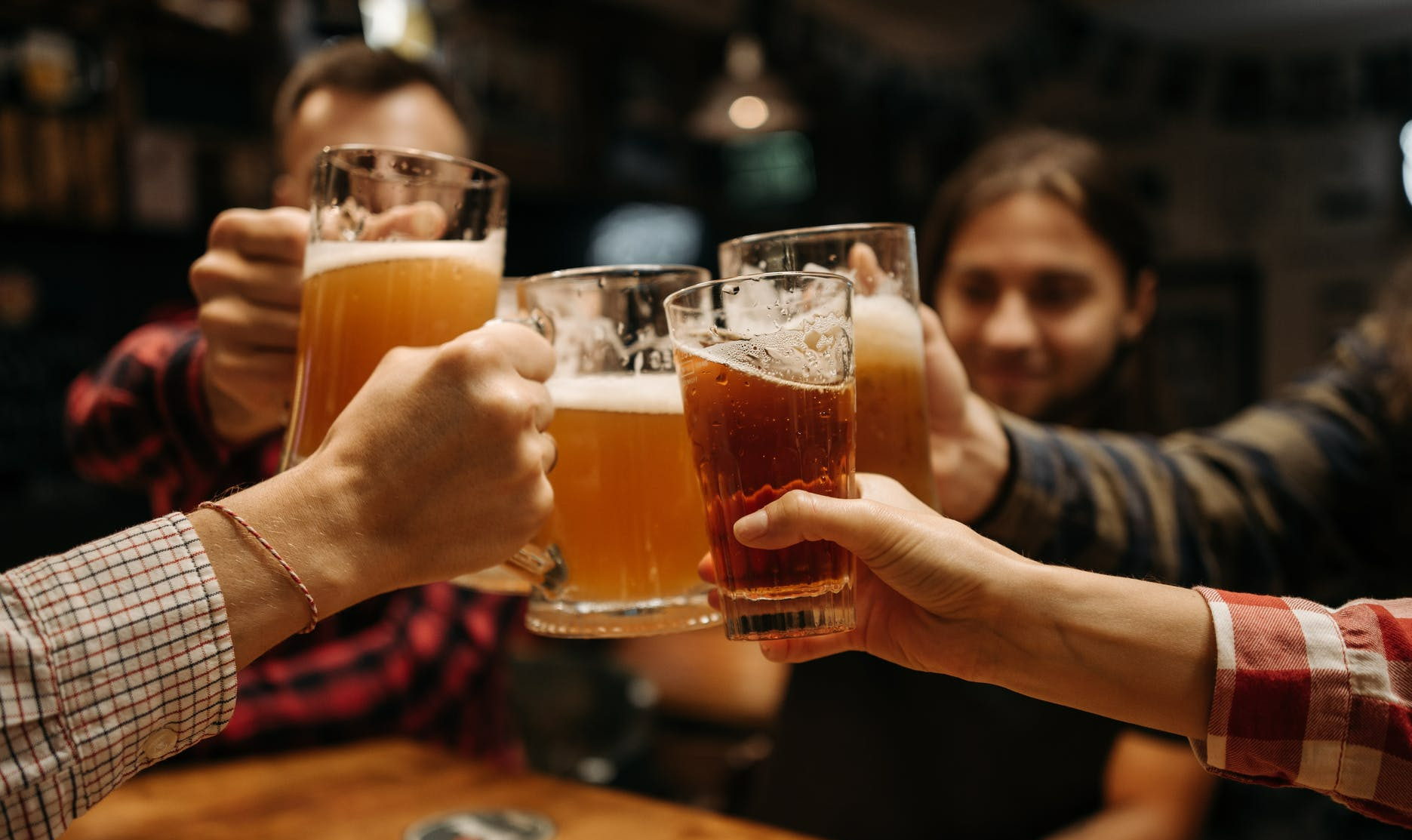 hands holding pints of beer