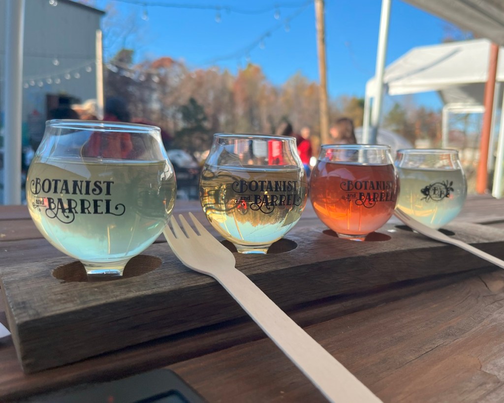 four tasting glasses in wooden holder